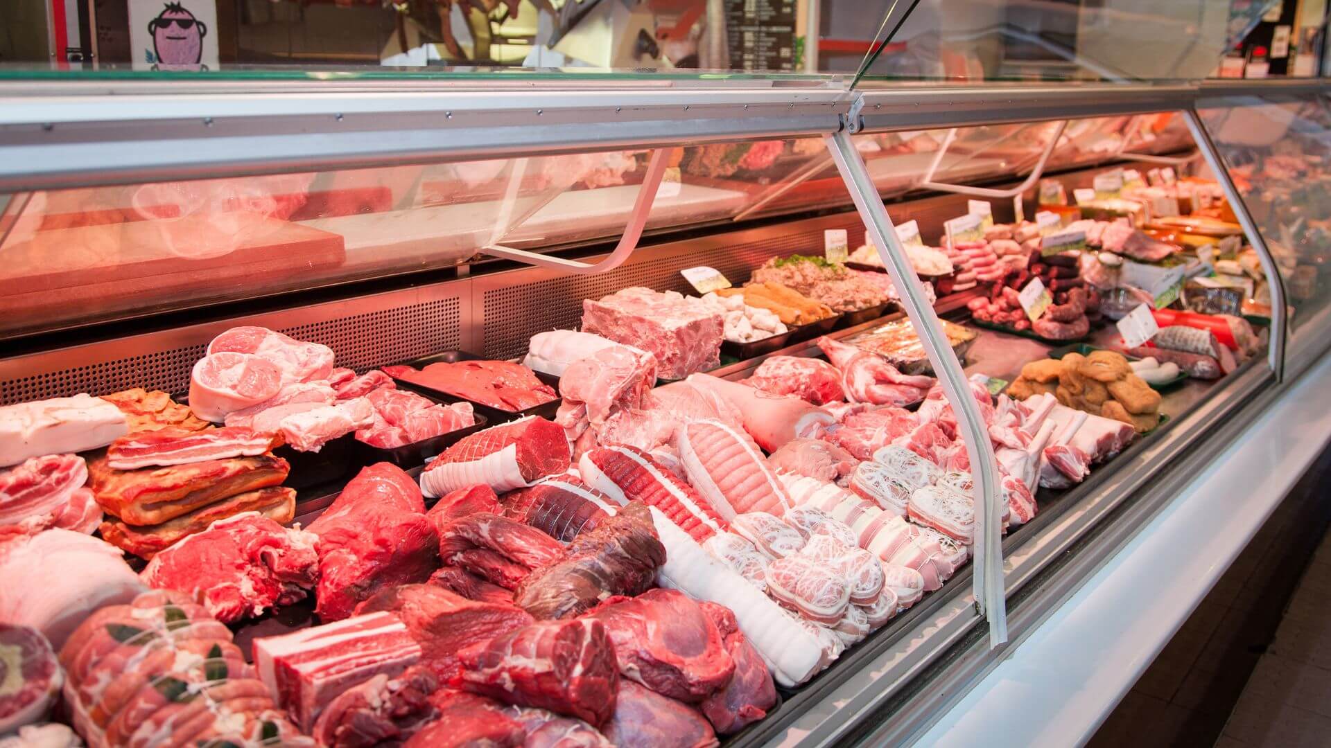 A long butcher case filled with fresh cuts of beef, pork, poultry, and seafood.